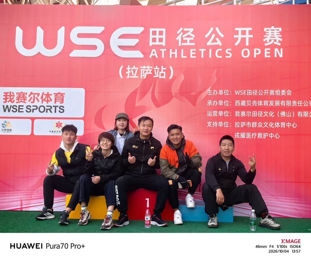 贝壳体育工作人员在赛事主背景板前合影